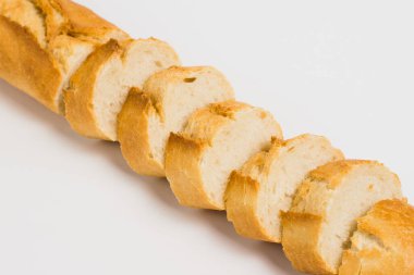 Appetizing French bun crust close-up. Sliced french baguette on a white background with space for text.