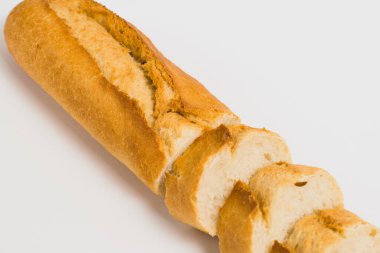 Appetizing French bun crust close-up. Sliced french baguette on a white background with space for text.