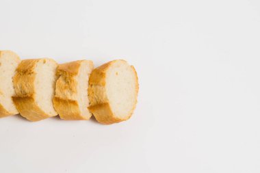 Pieces of crispy delicious French baguette on a white background.