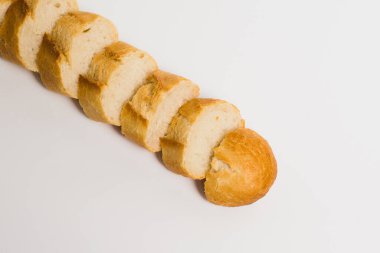 Pieces of crispy delicious French baguette on a white background.