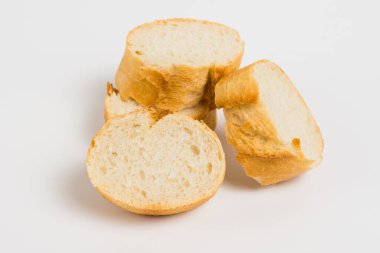 Pieces of French bread, baguette with an appetizing crust, on a white background, macro