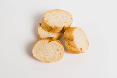 Pieces of French bread, baguette with an appetizing crust, on a white background, macro