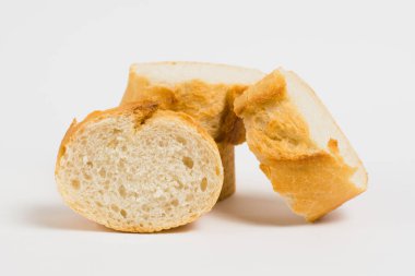 Pieces of French bread, baguette with an appetizing crust, on a white background, macro