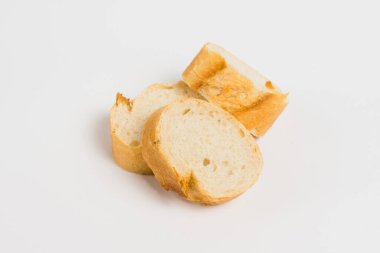 Pieces of French bread, baguette with an appetizing crust, on a white background, macro