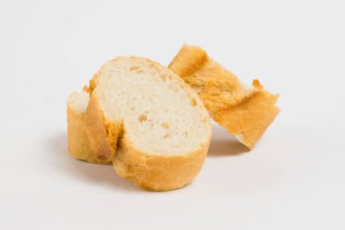 Pieces of French bread, baguette with an appetizing crust, on a white background, macro
