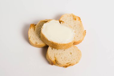 Pieces of baguette with an appetizing crust with butter, on a white background, macro. Concept of healthy eating