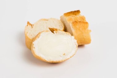 Pieces of baguette with an appetizing crust with butter, on a white background, macro. Concept of healthy eating