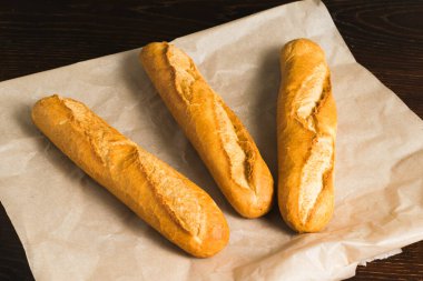Delicious baguettes close-up, on baking paper. Concept of development of craft bakeries.