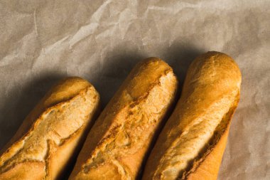 Delicious baguettes close-up, on baking paper. Concept of development of craft bakeries.