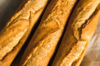 Delicious baguettes close-up, on baking paper. Concept of development of craft bakeries.