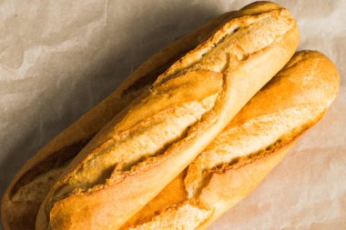 Delicious baguettes close-up, on baking paper. Concept of development of craft bakeries.