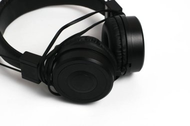 Black headphones with wire on a white background. Cheap headphones for listening to music.