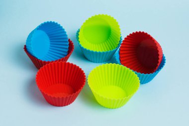 Set of new modern colorful bright silicone baking molds on blue paper background.