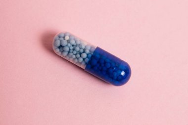 Pill macro on a pink background. The concept of improving the human body and protecting it from diseases