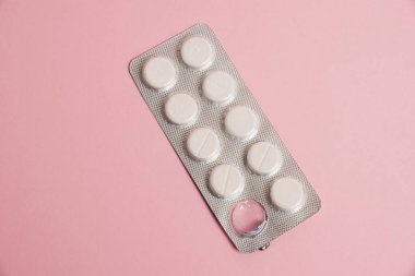 Opened blister pack with pills on a pink background. Concept of treatment of chronic diseases.