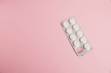 Opened blister pack with pills on a pink background. Concept of treatment of chronic diseases.