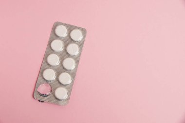 Opened blister pack with pills on a pink background. Concept of treatment of chronic diseases.