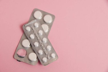 Opened blisters with pills on a pink background. Concept of treatment of chronic diseases.