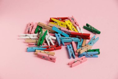 Many decorative, colorful, wooden clothespins on a paper background with copy space.