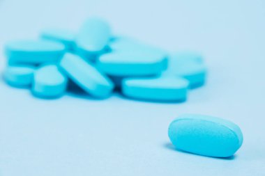Many blue pills macro on paper background with copy space.