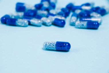 Pill macro on blue paper background with copy space.