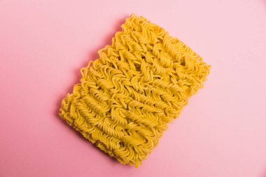 Flatlay, Pembe kağıt arkaplanda ham hazır şehriye fotokopi alanı.