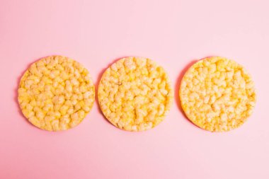 Yassı, çıtır çıtır, diyet mısır ekmeği pembe arka planda