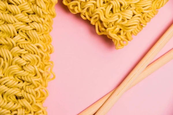 Μεγάλη Μερίδα Ωμής Στιγμιαίας Noodles Και Chopsticks Ροζ Χάρτινο Φόντο — Φωτογραφία Αρχείου