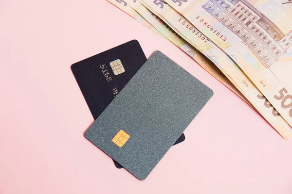 Bank cards with modern chips and money on a pink background. Concept of safe online operations with bank accounts and protection of bank cards from fraudsters.