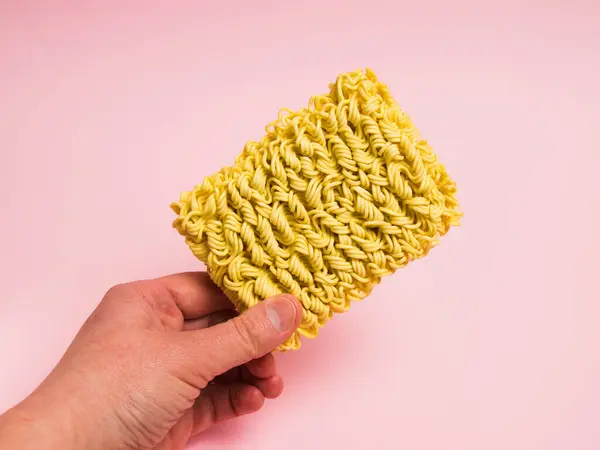 Ωμή Στιγμιαία Noodles Στο Χέρι Ροζ Φόντο — Φωτογραφία Αρχείου