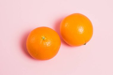 Pembe arka planda portakallar. Toprak günü kavramı, sıfır atık ve geri dönüşüm.