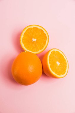 Pembe arka planda sulu portakal parçaları. Parlak bir arka planda lezzetli meyveler
