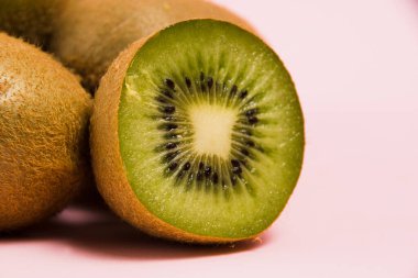 Pembe arka planda makro bölümde kivi. Parlak bir arka planda lezzetli meyveler