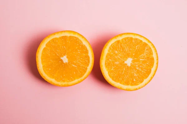 Stock image Juicy orange close-up cut in half on pink background. Delicious fruit on a bright background.