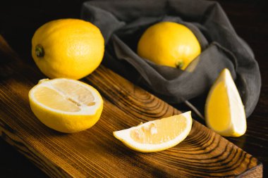 Kesme tahtasındaki limon dilimleri ve yeniden kullanılabilir meyve ağındaki bütün limonlar. Dünya günü ve sıfır atık kavramı.