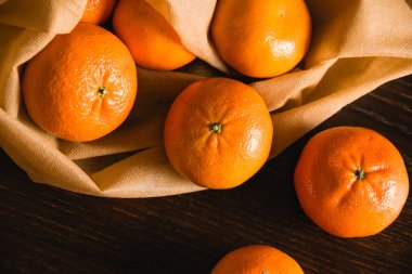 Toprak günü kavramı, geri dönüşüm ve sıfır atık. Koyu arkaplanda meyve ve sebzeler için tekrar kullanılabilir kahverengi bir çantada tatlı mandalinalar..