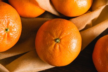 Toprak günü kavramı, geri dönüşüm ve sıfır atık. Koyu arkaplanda meyve ve sebzeler için tekrar kullanılabilir kahverengi bir çantada tatlı mandalinalar..