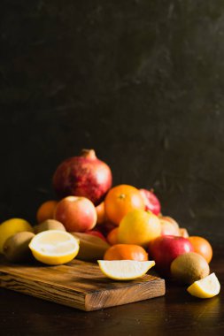 Tekrar kullanılabilir bir çantada meyve. Dünya günü ve sıfır atık kavramı. Kesme tahtasında dilimlenmiş limon, nar, portakal, mandalina, elma ve kivi..