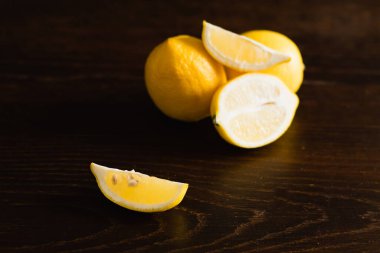 Koyu ahşap arka planda sarı sulu limonlar.