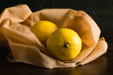 Dünya günü, geri dönüşüm ve sıfır atık kavramı. Meyve ve sebzeler için tekrar kullanılabilir kahverengi poşette sulu limonlar.