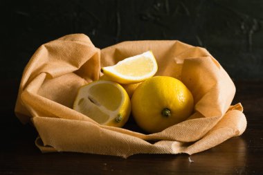 Dünya günü, geri dönüşüm ve sıfır atık kavramı. Meyve ve sebzeler için tekrar kullanılabilir kahverengi poşette sulu limonlar.