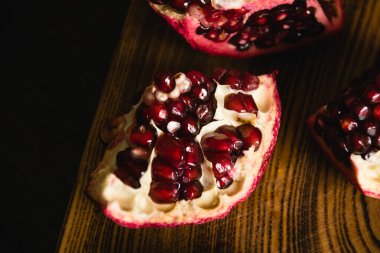 Koyu arkaplanda kesim tahtasındaki tatlı nar makrosu iştah açıcı..