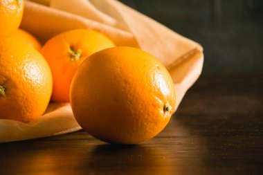 Toprak günü kavramı, gübreleme, sıfır atık ve geri dönüşüm. Arka planda sebze ve meyveler için yeniden kullanılabilir bir çantada portakallar.