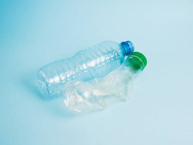 Mavi arka planda plastik şişeler. Dünya ve sıfır atık kavramı.