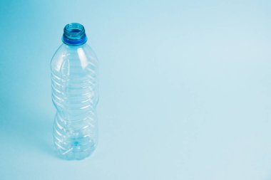 Mavi arka planda şeffaf plastik şişe. Toprak günü kavramı, sıfır atık ve plastik geri dönüşümü