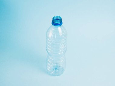 Mavi arka planda şeffaf plastik şişe. Toprak günü kavramı, sıfır atık ve plastik geri dönüşümü