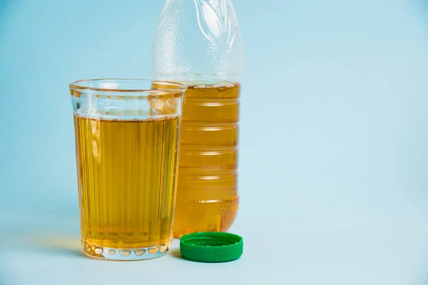 ペットボトルでジュースを飲み 青紙の背景に再利用可能なガラスカップ 地球の日 廃棄物ゼロ プラスチックリサイクルの概念 — ストック写真
