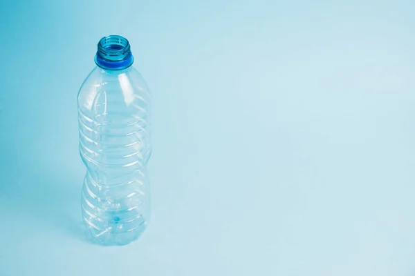 Transparent plastic bottle on the blue background. Concept of earth day, zero waste and plastic recycling
