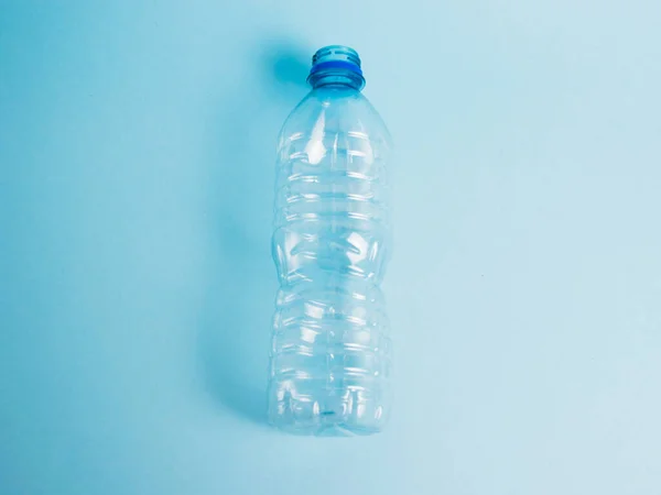 Transparent plastic bottle on the blue background. Concept of earth day, zero waste and plastic recycling