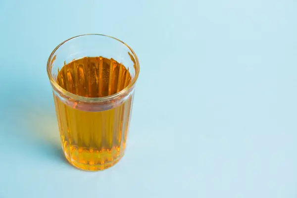 青い紙の背景にジュースのガラス 健康的な食事の概念 — ストック写真